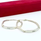 Silver infinity charm bracelets for couples on a white surface with a red box behind them.