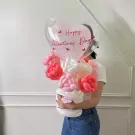 Heart balloon with "Happy Valentine's Day" and a bouquet of pink and white balloon roses in a white balloon vase.