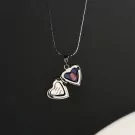 Silver heart-shaped locket necklace with a photo of a child and text that reads "when we meet again".