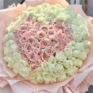 A heart-shaped bouquet of 99 pink roses surrounded by white roses.