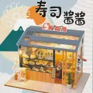 Miniature sushi restaurant model with display cases full of sushi and interior seating.