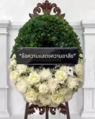 Floral wreath with a black banner and Thai text, featuring white roses and green leaves.