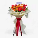 Bright orange and red gerbera daisies with greenery in a floral stand, tied with a red ribbon.