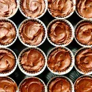 A top-down view of nine chocolate fudge brownie bites in white paper liners.