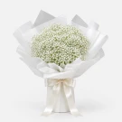 A bouquet of white baby's breath flowers wrapped in white paper and tied with a cream ribbon.
