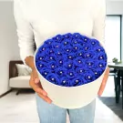 Round white box filled with 40 blue artificial roses with diamond centers, held by a person.