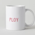 White mug with pink text "PLOY" on a light gray background.