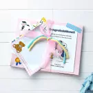 Pink gift box with a congratulations card, a teddy bear sticker, and a pink ribbon.