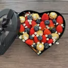 Heart-shaped box of strawberries, blueberries, and Ferrero Rocher chocolates.