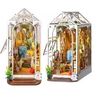 Two detailed wooden miniature garden houses with plants, furniture, and lights.