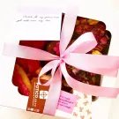 Gift box with pink ribbon, handwritten note, and Frosted Sugar Cookies Box.