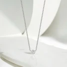 A solitaire moissanite diamond necklace in 18K white gold plating.
