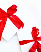 Two white gift boxes tied with red ribbon bows, on a white background.
