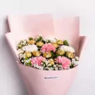 Bouquet of pink and white carnations and Ferrero Rocher chocolates, wrapped in pink paper.
