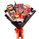 Halloween snack bouquet with treats, wrapped in black paper and tied with orange ribbons.