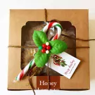 Christmas gift box with candy cane, holly, and "Merry Christmas" tag, containing gingerbread butter cookies.