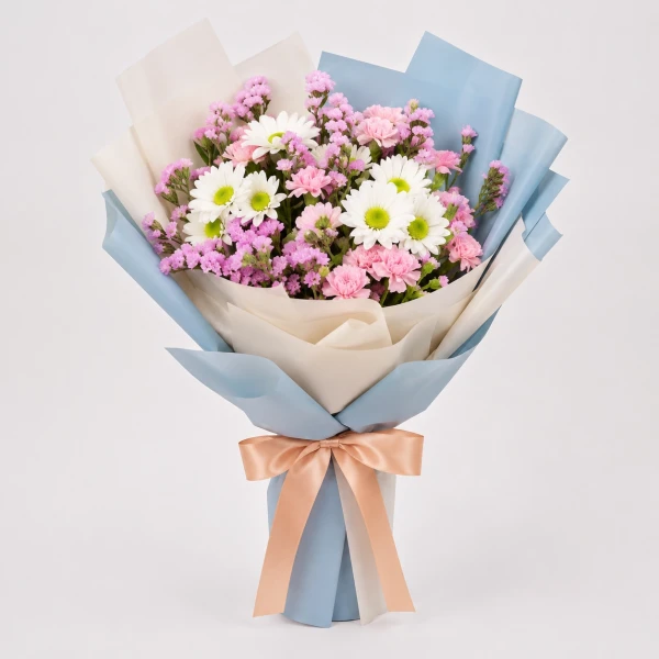 A bouquet of pink and white flowers, including mums, carnations, and statice, wrapped in blue and white paper and tied with a peach ribbon.