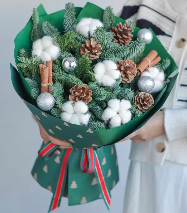 Christmas bouquet with pine, cotton, pine cones, cinnamon, and silver ornaments.