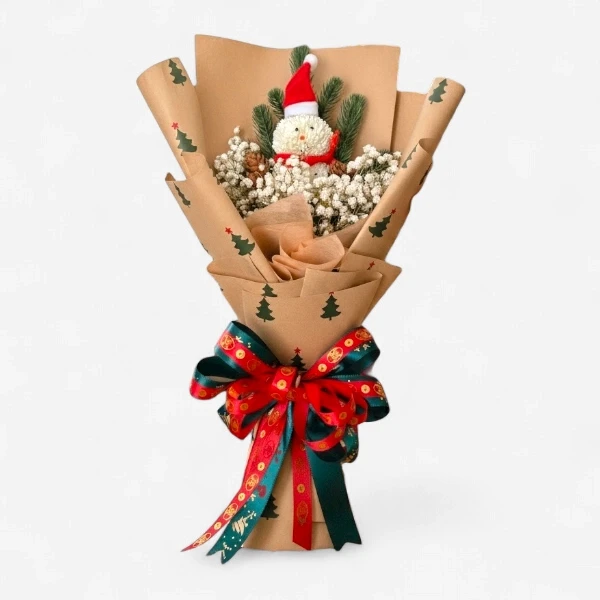 A Christmas bouquet with a snowman decoration, white flowers, pine sprigs, and a festive ribbon.