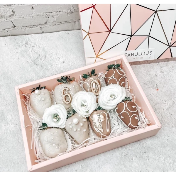 Mini gift box of chocolate-dipped strawberries with white flowers.