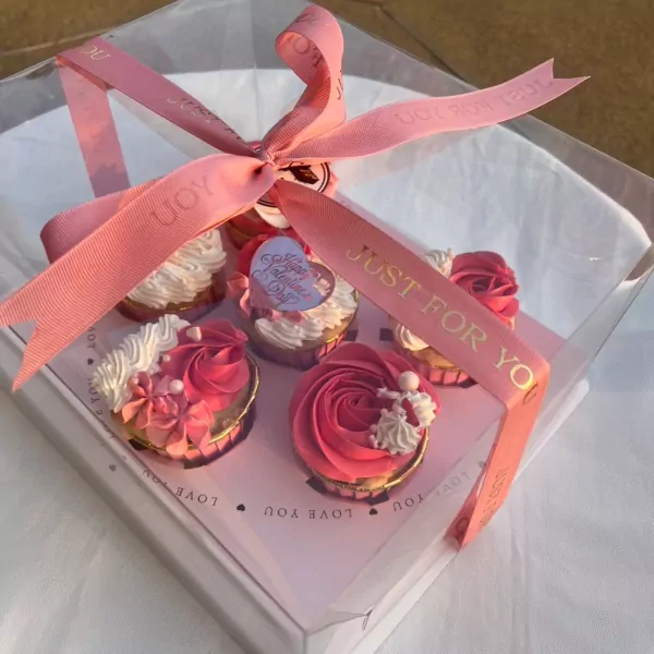 Six Valentine's Day cupcakes in a gift box, tied with pink ribbon.