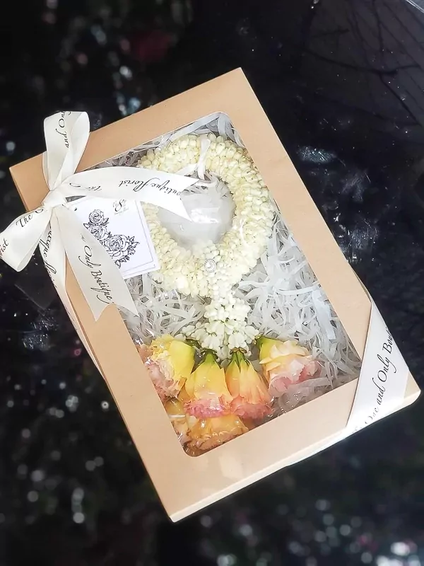 Golden Fresh Malai with yellow and pink flowers in a box.