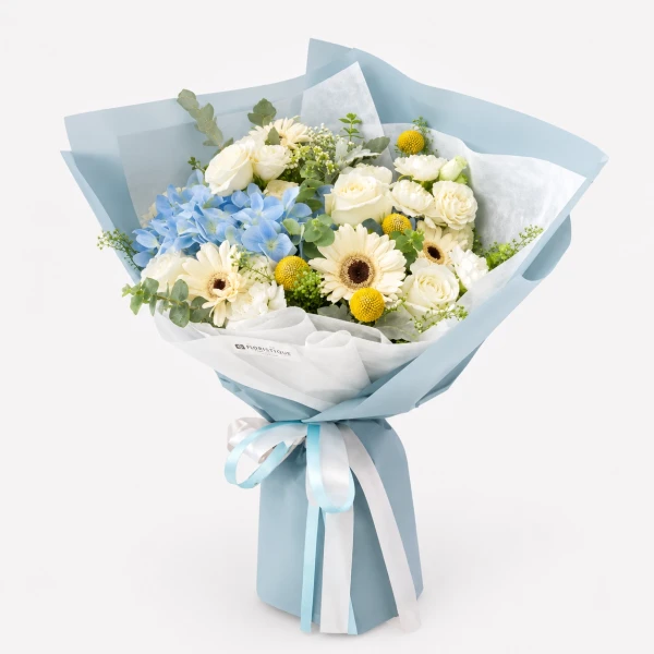 A light blue and white bouquet with blue hydrangeas, white roses, and yellow flowers, wrapped in blue paper.