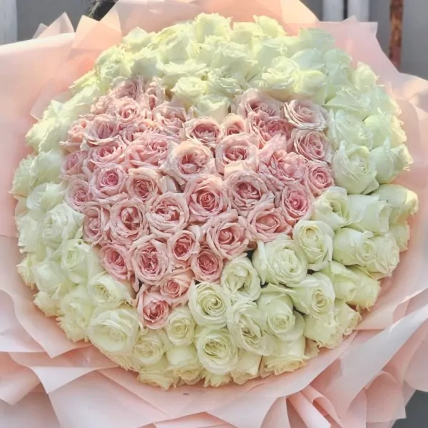 A heart-shaped bouquet of 99 pink roses surrounded by white roses.