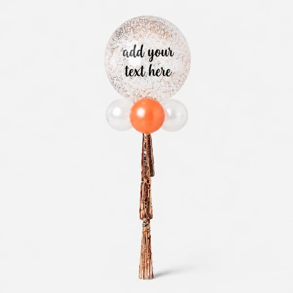 A 24" clear glitter balloon with "Happy Birthday GATTUI" written on it, with smaller white and orange balloons below and rose gold tassels.