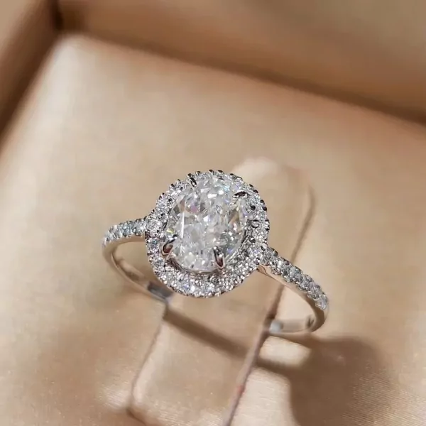 1-carat oval-cut moissanite diamond ring with halo on white gold plated sterling silver band.