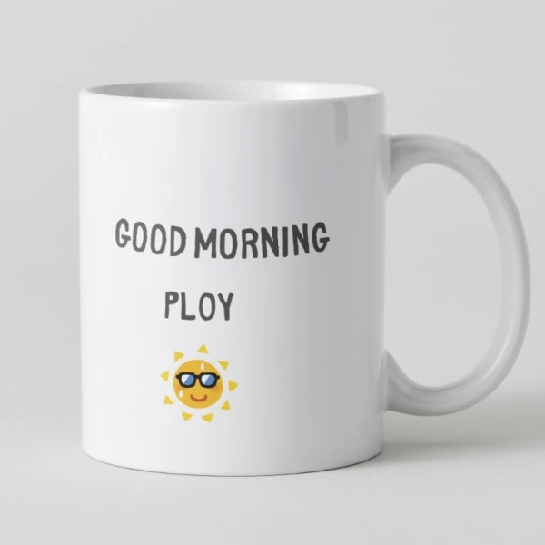 White mug with "GOOD MORNING PLOY" and a smiling sun with sunglasses.