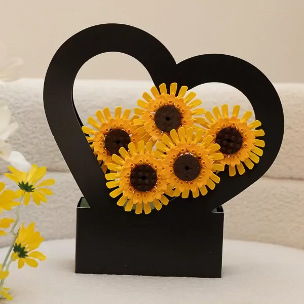 LEGO sunflowers in a black heart-shaped basket, with real sunflowers in the foreground.