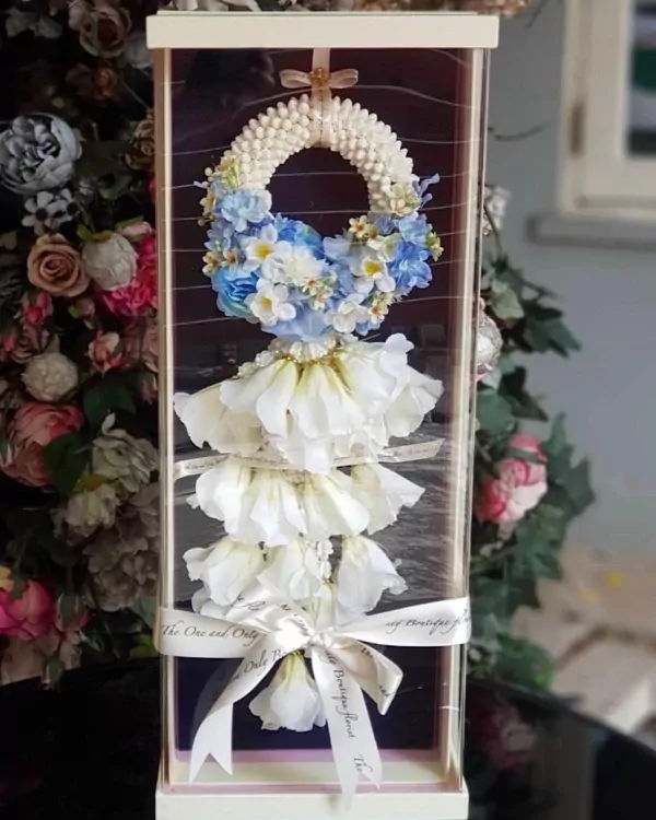 Artificial jasmine and blue flower malai in a gift box, decorated with ribbons.