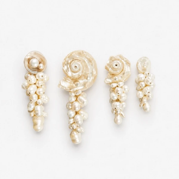 Seashell and pearl earrings with a torn paper background.