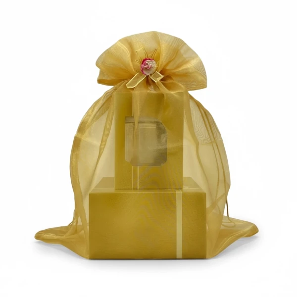 Gold organza gift bag with a decorative rose, containing a stacked set of golden boxes.