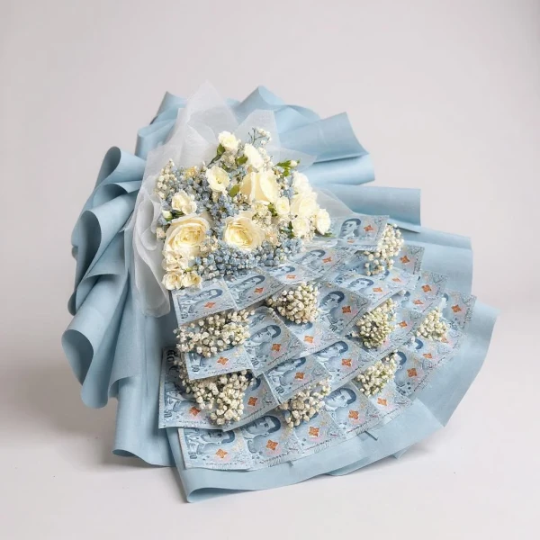 Money bouquet with white roses and baby's breath, wrapped in blue paper.