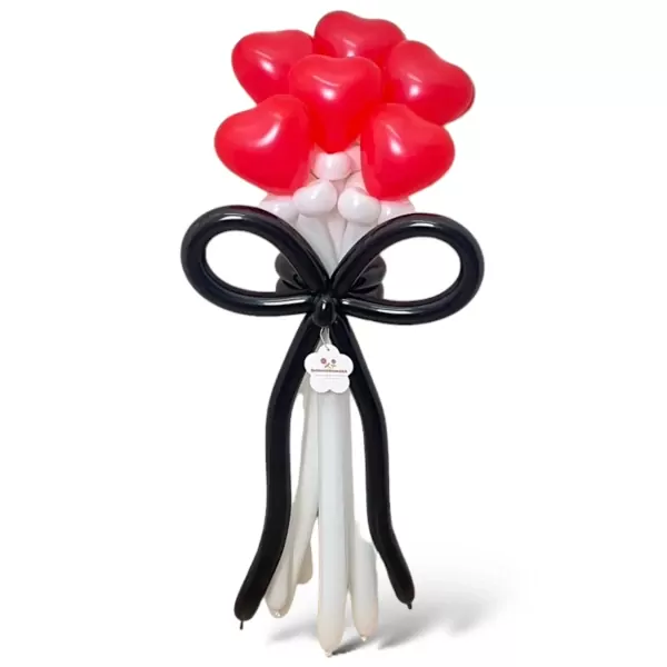 Balloon arrangement of red heart balloons and a black bow with white balloon streamers.