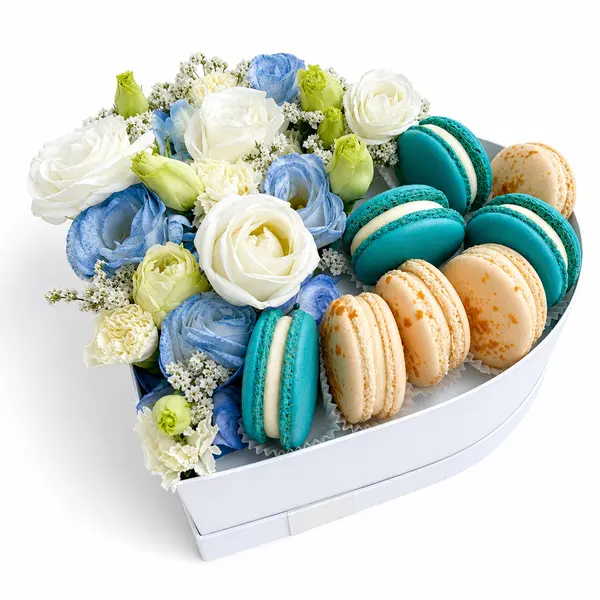 Heart-shaped box with blue and white flowers and blue and vanilla macarons.