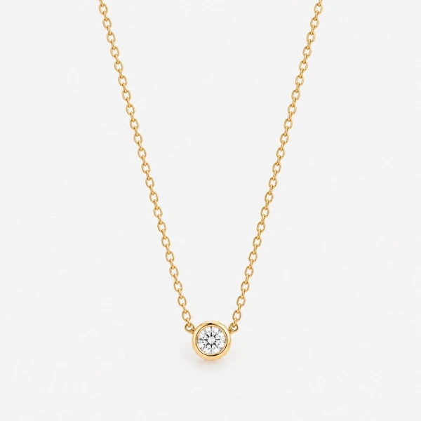 Gold chain necklace with a single, bezel-set moissanite diamond pendant.
