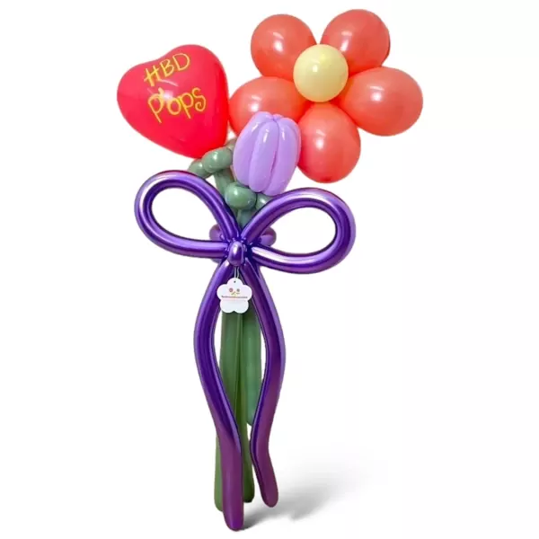 A balloon bouquet with a red heart, orange daisies, and purple tulips, tied with a purple ribbon.