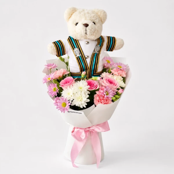 Graduation bouquet with a teddy bear in a Chula gown, surrounded by pink and white flowers and a pink ribbon.