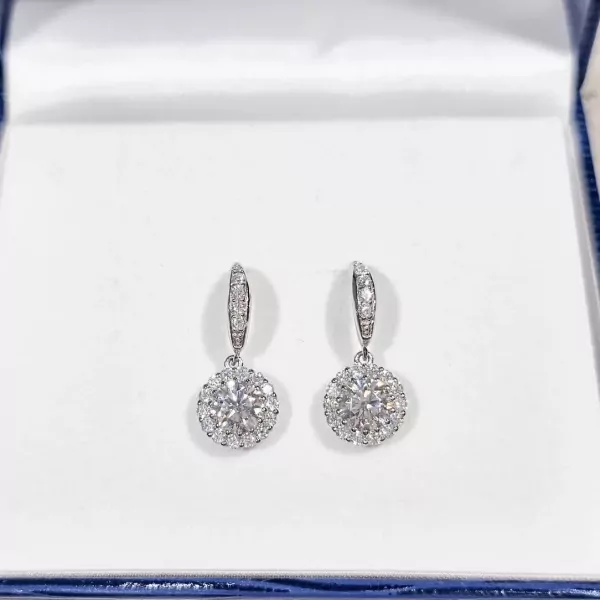 1-carat round moissanite diamond halo drop earrings in a jewelry box.