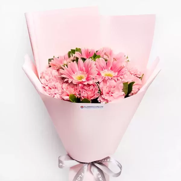 Pink gerbera and carnation bouquet wrapped in pink paper with grey ribbon.