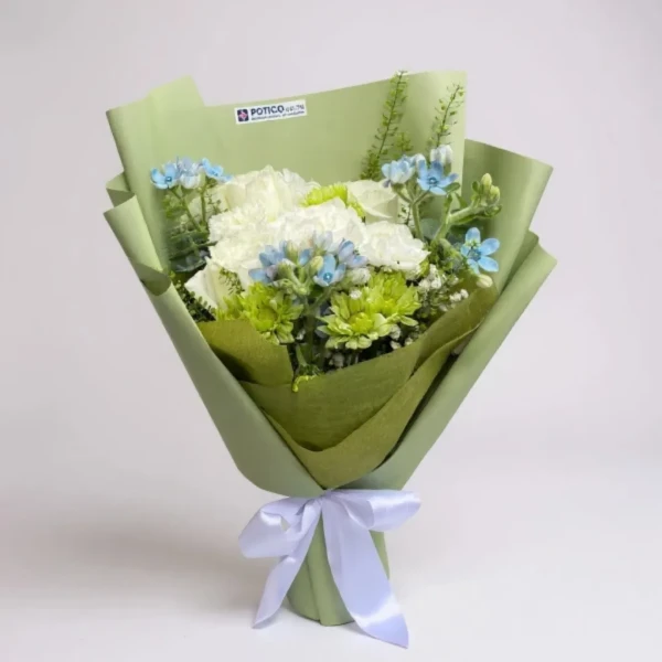 White and green flowers with blue accents, wrapped in light green paper and tied with a white ribbon.
