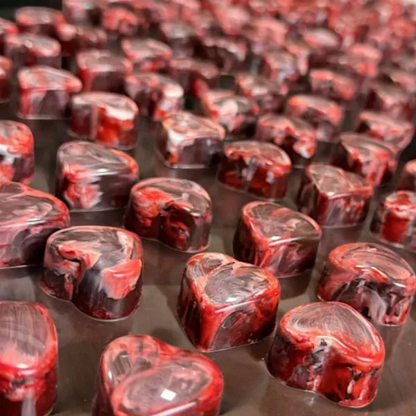 Heart-shaped chocolates with swirling red and white marbling.
