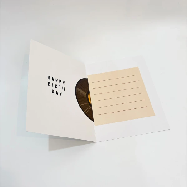 Open birthday card with "Happy Birthday" text, a vinyl record cutout, and a lined message space.
