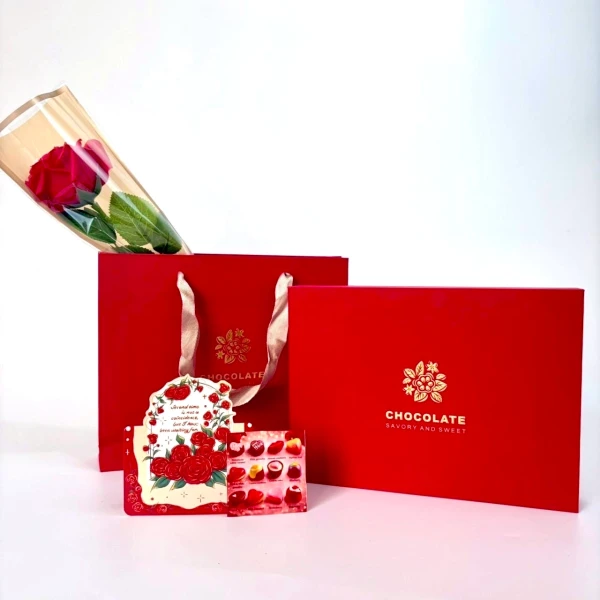Red box of 12 chocolates with a rose bouquet and card.