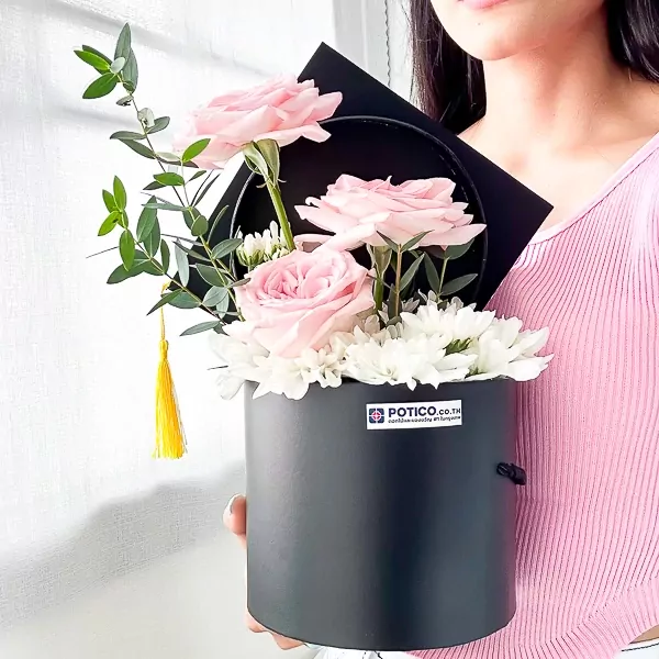 Black graduation box with pink roses, white mums, and yellow tassel.
