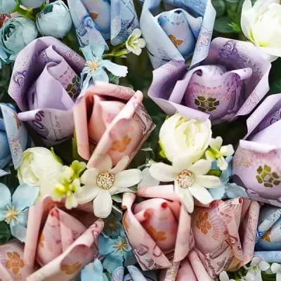 Money bouquet with pink, purple, and blue flowers made from banknotes.