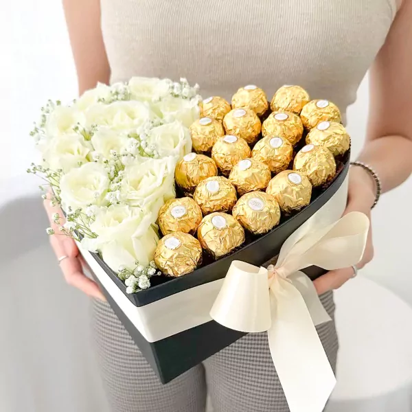 Heart-shaped box with white roses and Ferrero Rocher chocolates.